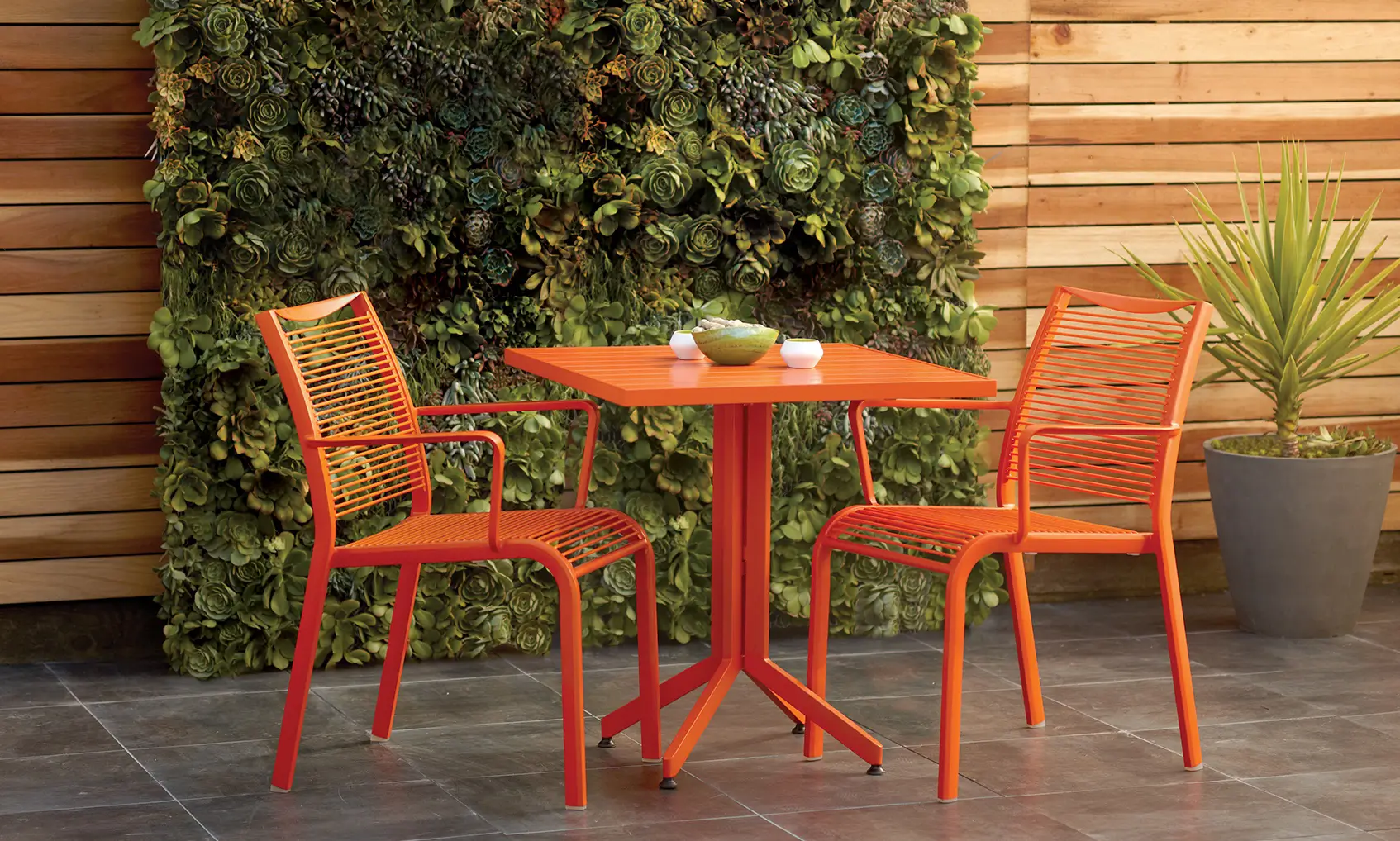 Scandanavian Designs brand environmental photography of orange outdoor dining set.