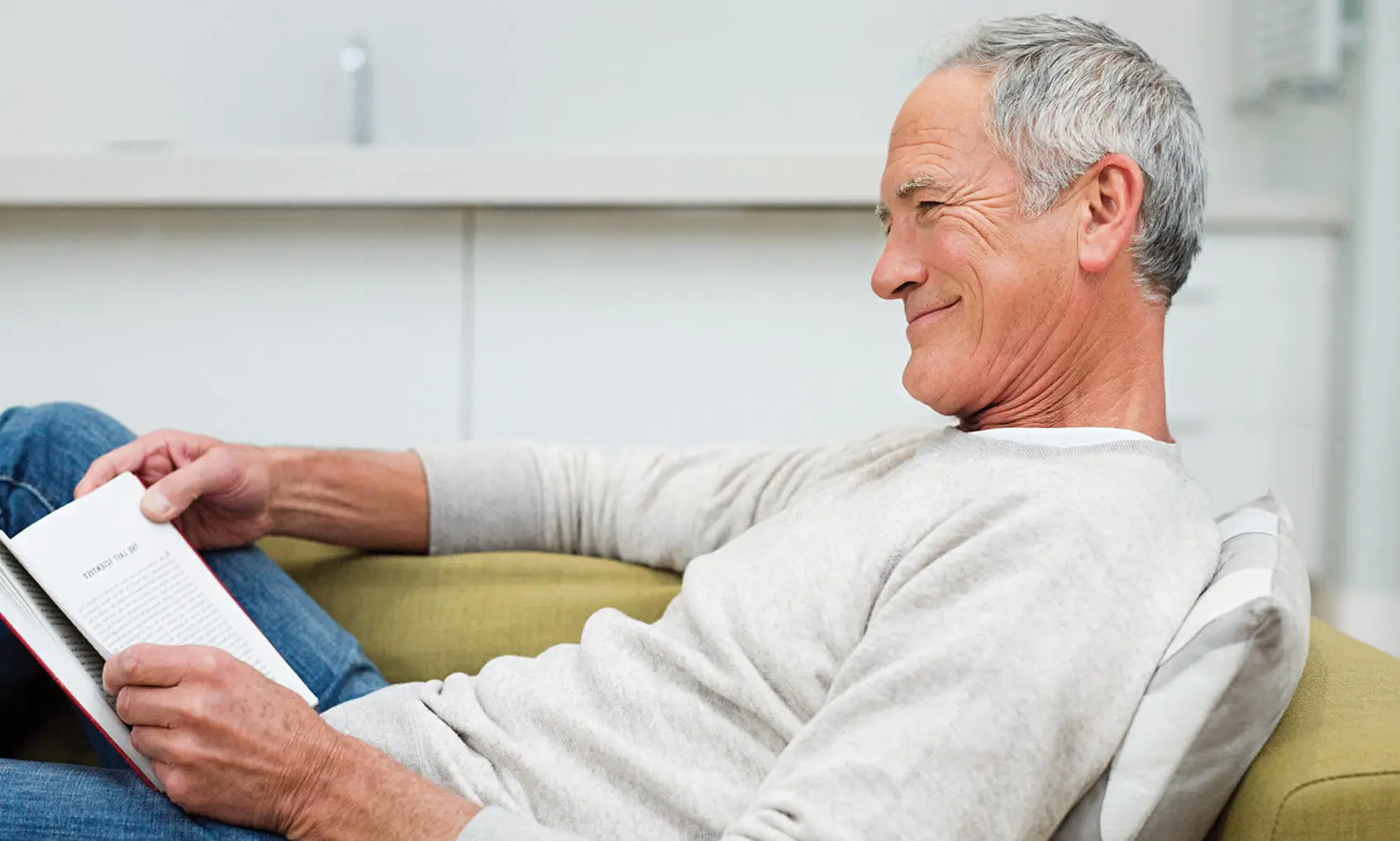 Scandanavian Designs brand lifestyle photography of man siting on green couch.