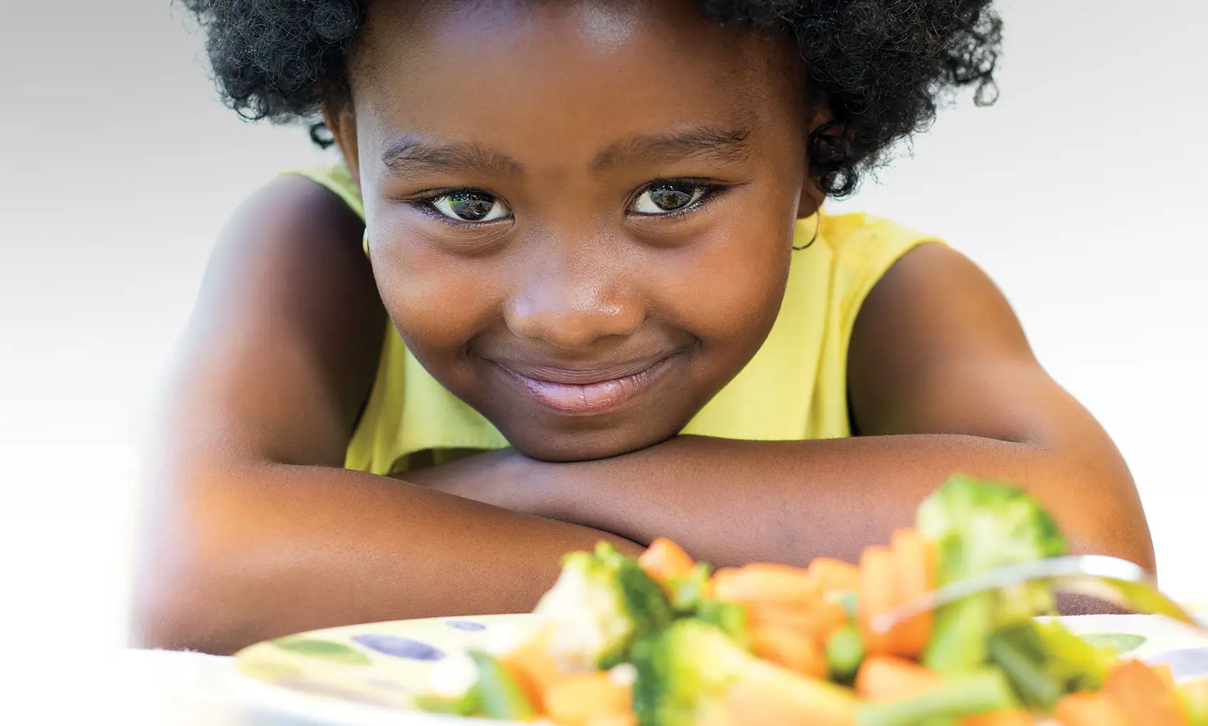 Chid enjoying Eat Smart salad in a bowl.